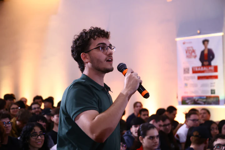 Estudante participa da programação com o público ao fundo