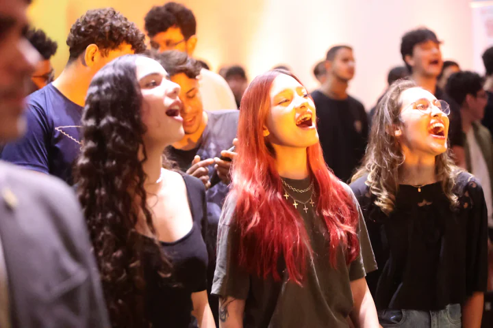 Participantes cantam e celebram durante o evento
