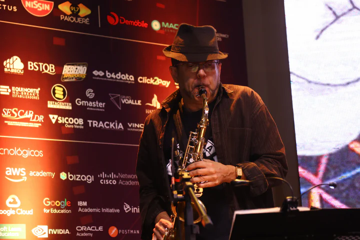 Músico toca saxofone diante do painel da TechFil