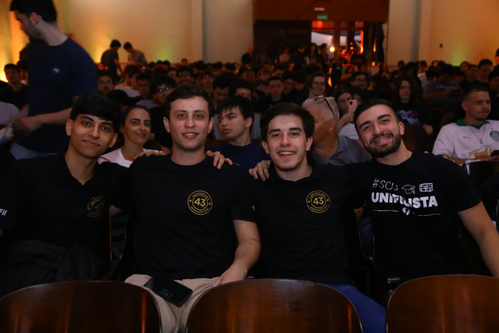 Grupo de amigos se reúne sorrindo diante da plateia